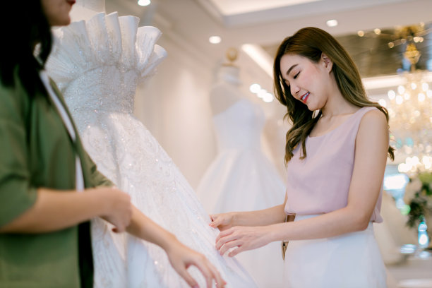 新娘店女老板在婚庆工作室工作。新娘婚纱店老板在店里工作。女设计师在店里制作婚纱。图片下载