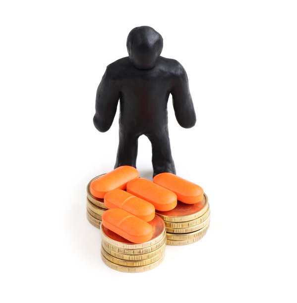 橙色药丸和金币被隔离在白色背景上。橙色维生素堆分离图片下载