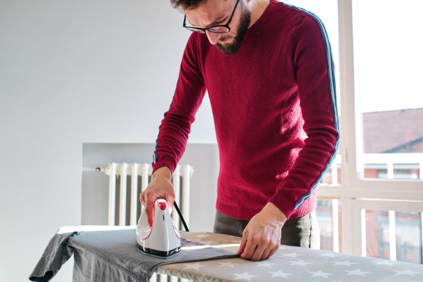 专心的男人在家熨衬衫图片下载