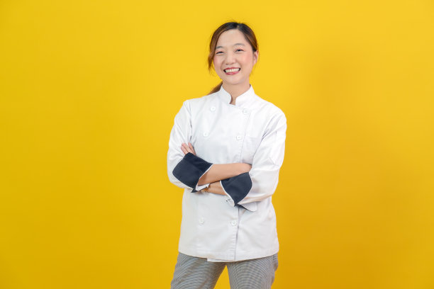 身着专业厨师制服的年轻亚洲女性双臂交叉站立的肖像图片下载