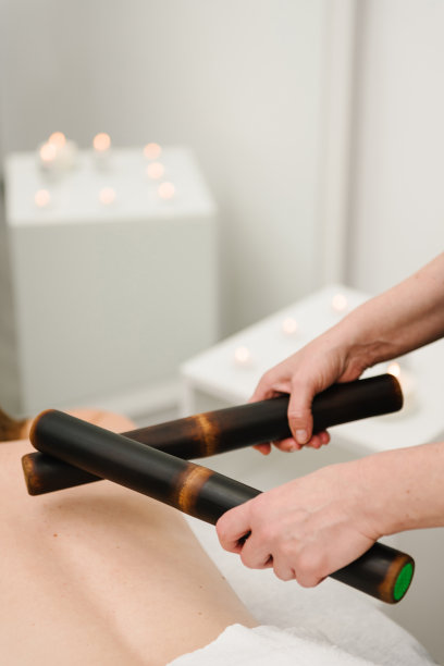 在健康水疗中心，女按摩师用竹棒按摩背部。概念按摩水疗。美体按摩，淋巴引流，手工美容美发。特写镜头。图片下载