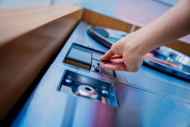 年轻女子在洗衣店把硬币放进洗衣机图片下载