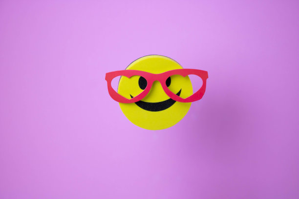 带着红眼镜的笑脸，他的影子在粉红色的背景上图片下载