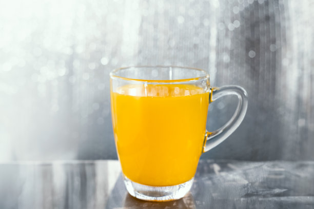 一杯橙汁，闪亮的银色背景图片下载