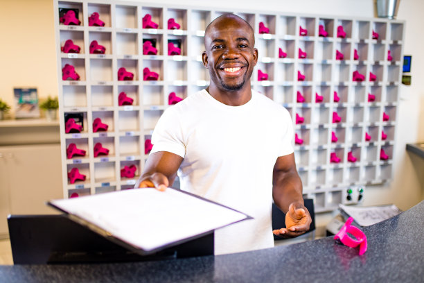 在健身房的接待处，肌肉发达的美国混血儿微笑着迎接克林特图片下载