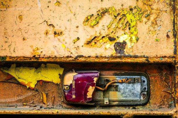 正宗的老式工业背景。旧压路机脏脏的部分特写。橙色的金属。图片下载