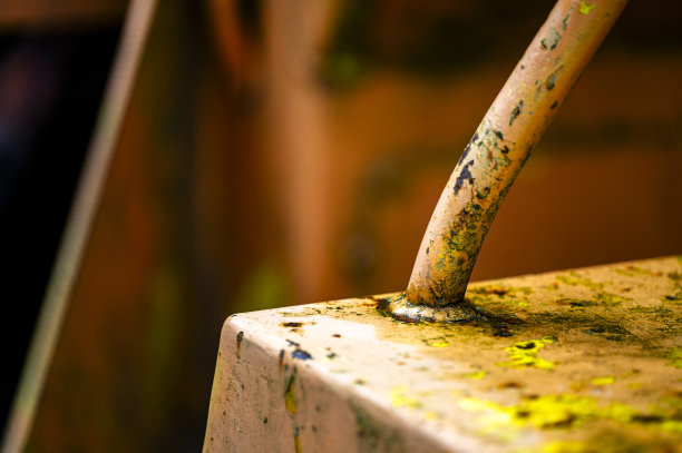 正宗的老式工业背景。旧压路机脏脏的部分特写。橙色的金属。图片下载
