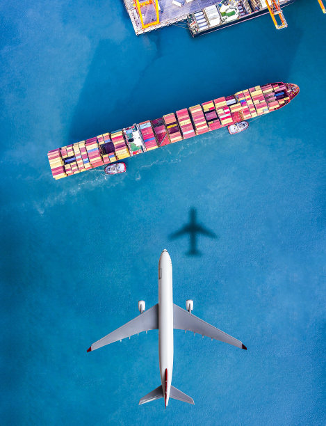 在货轮上方飞行的飞机。图片下载