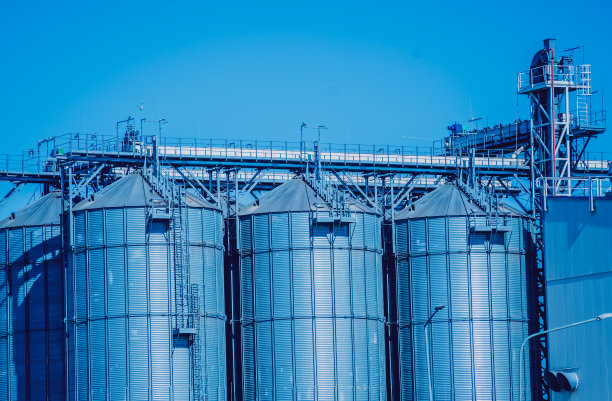 在蓝天背景下储存谷物收获的现代筒仓。图片下载