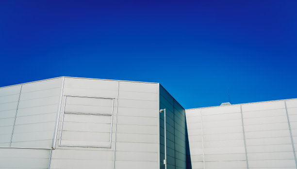现代大型工业仓库建筑以蓝天为背景。图片下载