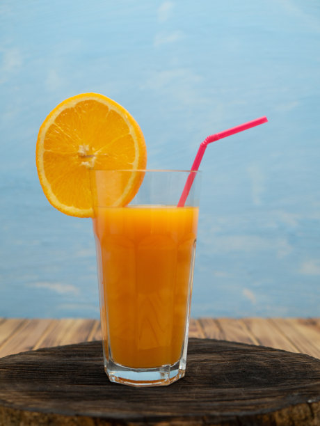 一杯橙汁，加一片橙片和一根吸管图片下载