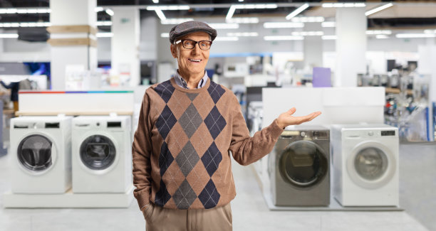 一位老人在商店里展示洗衣机图片下载