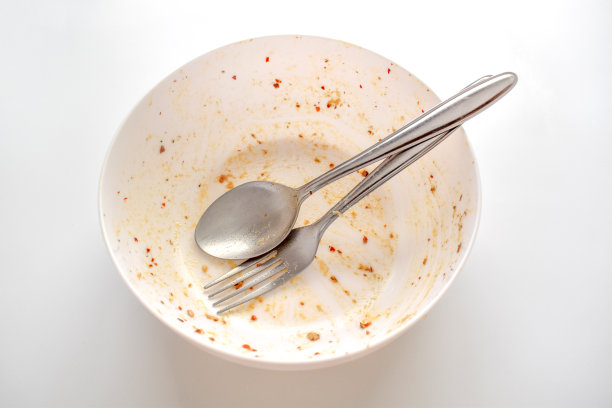 脏碗，叉子和勺子放在桌子上。图片下载