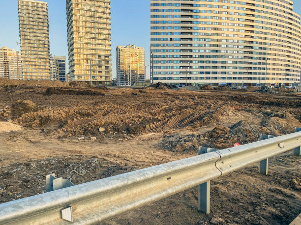 桥在新社区。梁上的混凝土桥，靠近泥土，水坑。高层建筑背景下的新微区基础设施建设图片下载