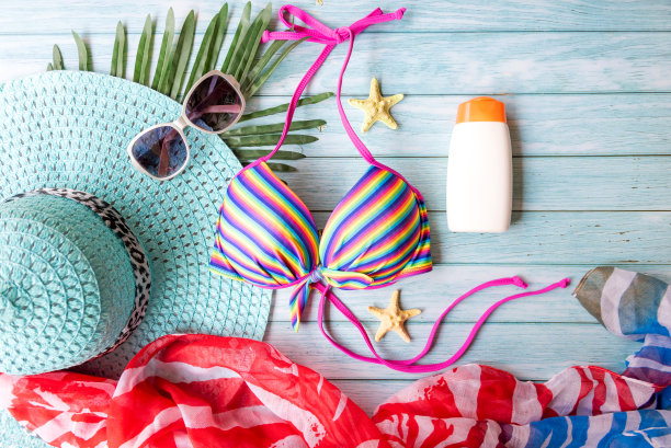 夏季项目时尚女性泳衣比基尼，防晒霜和旧相机。旅游度假在假日，蓝色木制背景，俯视图。夏天的概念图片下载