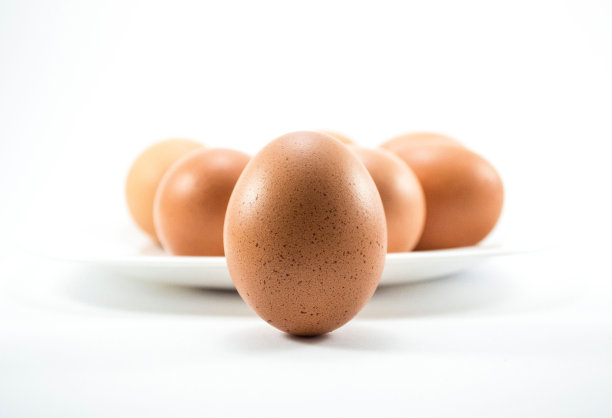 白色盘子上的棕色鸡蛋特写图片下载