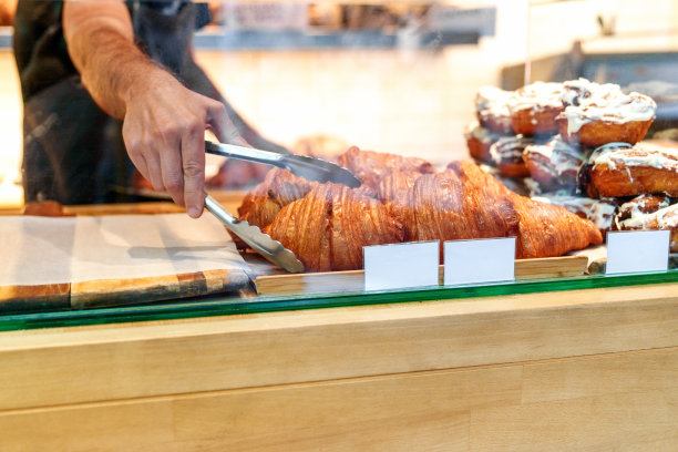 工匠面包师展示新鲜出炉的美食与价格标签图片下载