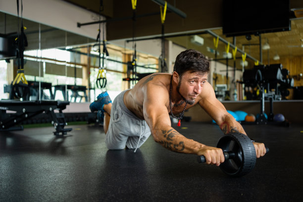 在健身房使用腹肌轮的人图片下载