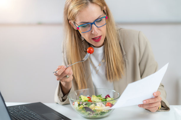 在工作场所吃新鲜沙拉的女人图片下载