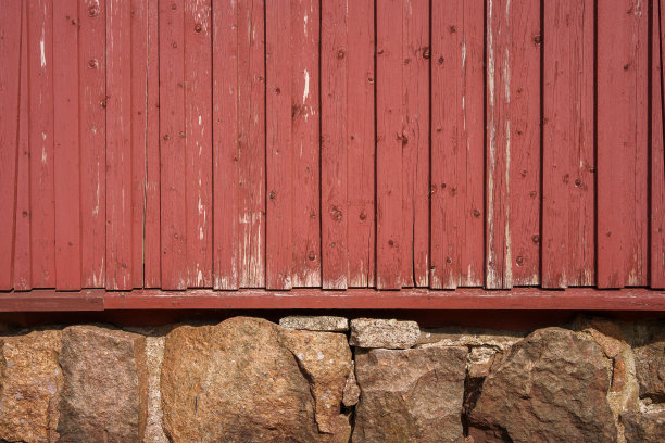 芬兰一座老房子的红色木墙和石头地基。图片下载