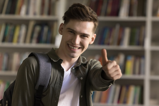 男学生在图书馆摆姿势，对着镜头竖起大拇指图片下载