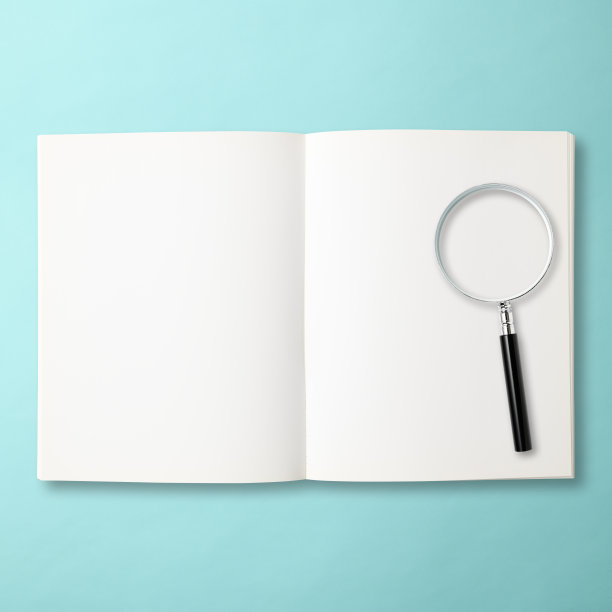 用放大镜在浅蓝色背景上检查一本打开的空白书图片下载