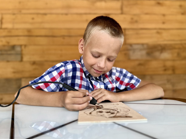 一个男孩用燃烧装置在黑板上画画图片下载