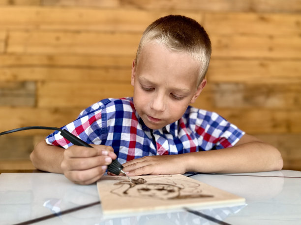 一个男孩用燃烧装置在黑板上画画图片下载