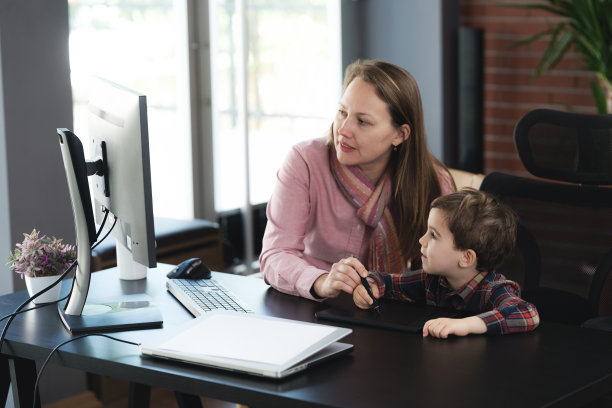 母亲在家里教儿子如何用绘图板绘制电脑辅助数码图像图片下载