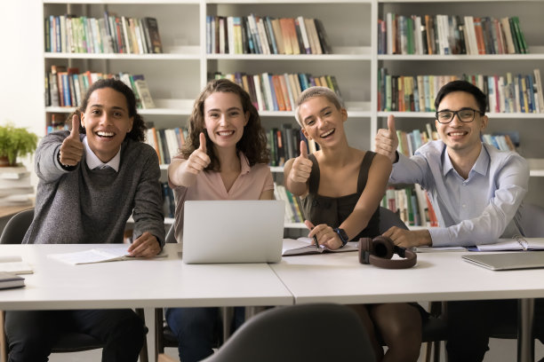 兴高采烈的年轻大学生在校园图书馆摆姿势图片下载