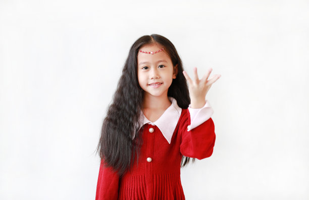 漂亮的小女孩的肖像，穿着猩红色的裙子，带着微笑和表情，手拿着白色背景的东西。图片下载