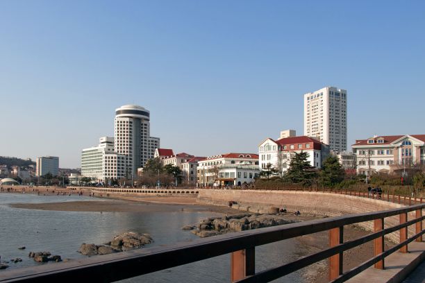 在中国青岛，海滨木板路与建筑物相映成趣图片下载