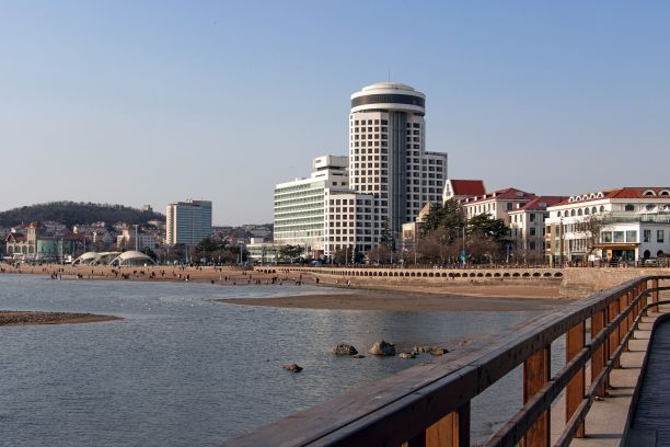 在中国青岛，海滨木板路与建筑物相映成趣图片下载