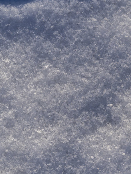 特写的积雪是一个抽象的自然背景。白雪覆盖的土地的微距照片，在寒冷的冬天的雪花。雪层:有光泽的积雪的质地图片下载