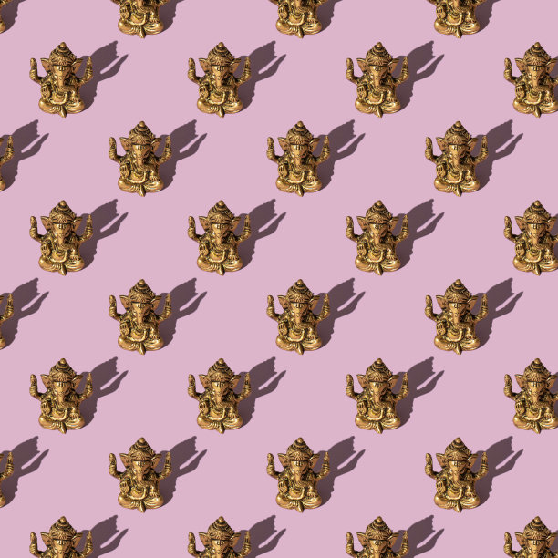 图案与主甘尼萨雕像，由青铜制成，粉红色的背景。甘尼萨节概念图片下载