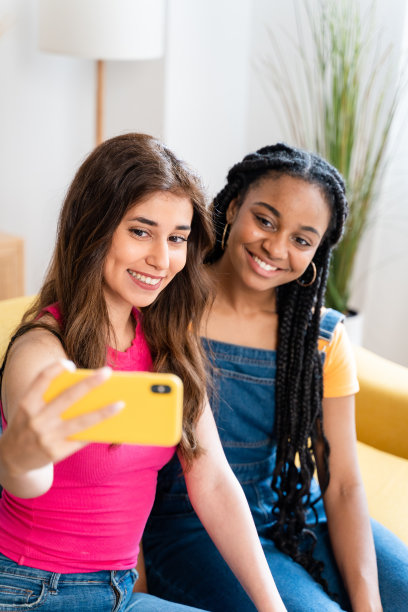 开心的女性朋友在家里自拍。图片下载