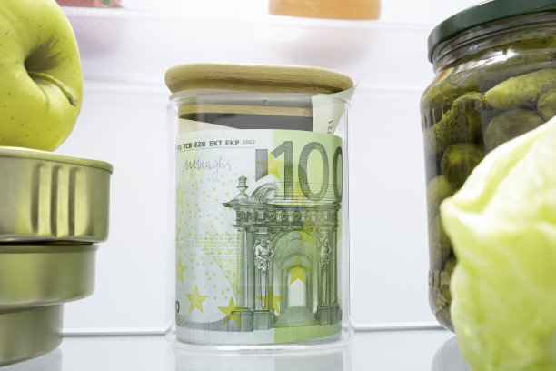 钞票、欧元现钞装在玻璃罐里，罐头食品等食品放在冰箱里。节约现金的概念，影子经济，偷税漏税，糟糕的经济决策图片下载