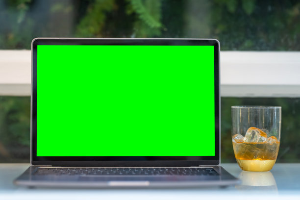 空白屏幕的笔记本电脑模型，冰咖啡放在一个玻璃杯子里，隔离在咖啡店的木制办公桌上，像背景一样，白色屏幕图片下载