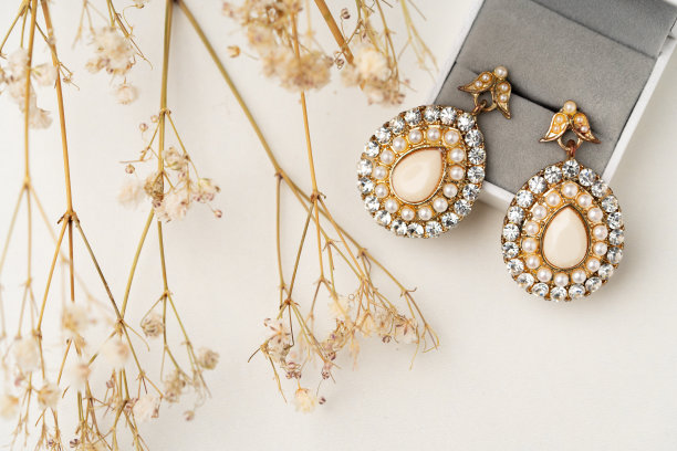 桌子上的金耳环和首饰盒特写图片下载