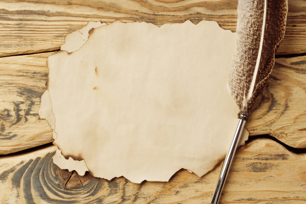 旧纸在棕色的木头背景与羽毛图片下载