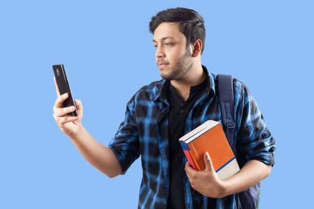 学生使用蓝色背景的手机图片下载