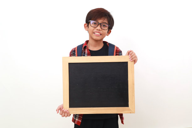 快乐的亚洲学生举着空白黑板站着。孤立于白色图片下载