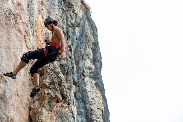 亚洲年轻人在热带岛屿的岩石山上爬山度假图片下载