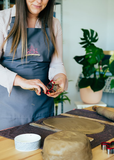 一个匿名微笑的女人在她的工作间用粘土制作圣诞装饰品图片下载