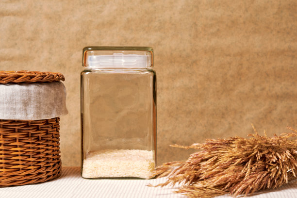 白色的生米，小麦穗和一个篮子放在农村厨房的桌子上图片下载