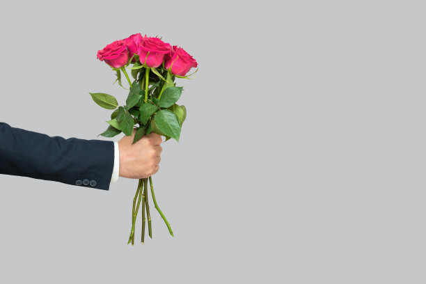 一个男人手里拿着一束粉红色的玫瑰图片下载
