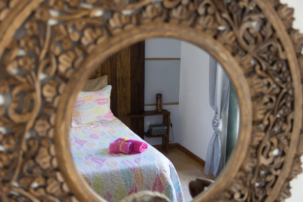 木镜里的倒影，聚焦在一张彩色的床上，床上卷着紫色的毛巾图片下载