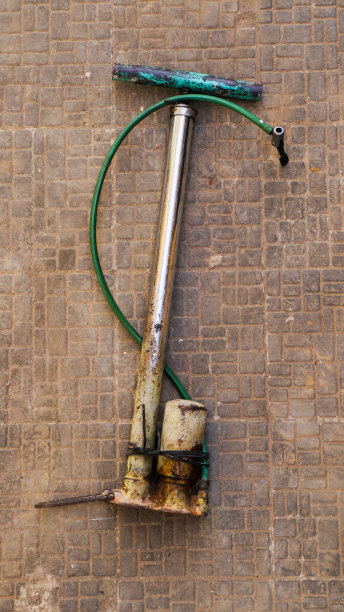 一个旧的手动气泵，一些生锈的部件仍然可用。图片下载