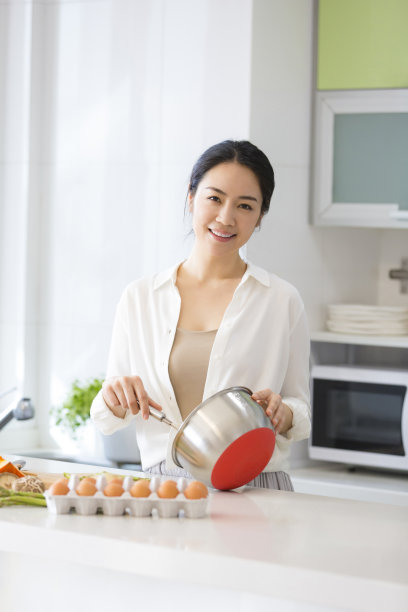 年轻的家庭主妇在厨房里准备食物的照片图片下载