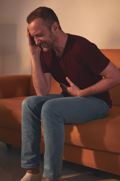家里有胃痛和头痛的男人。图片下载